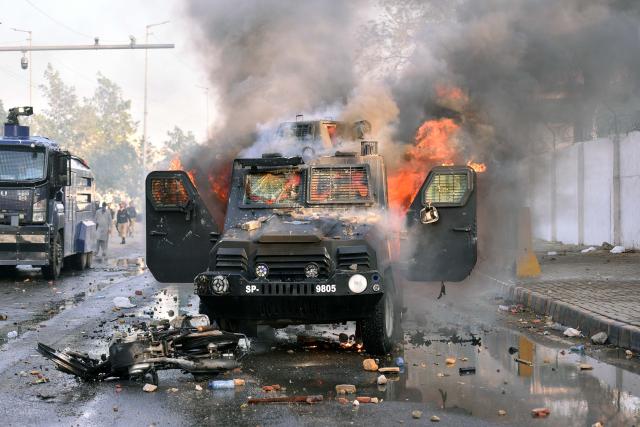 (260302) -- KARACHI, March 2, 2026 (Xinhua) -- A police vehicle is set on fire during clashes between anti-U.S. protesters and law enforcement personnel near the U.S. Consulate in southern Pakistani port city of Karachi on March 1, 2026. Twenty people were killed and over 100 others injured in anti-U.S. demonstrations in Pakistan on Sunday, police sources told Xinhua. (Photo by Imran Ali/Xinhua)