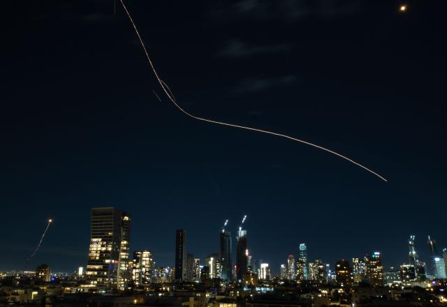 (260302) -- TEL AVIV, March 2, 2026 (Xinhua) -- This long exposure photo taken on March 1, 2026 shows flare trails left by interceptor missiles launched from Israeli air defense systems in Tel Aviv, Israel. Multiple explosions were heard in Tel Aviv on Sunday, eyewitnesses said, as Israel's military said it was operating to intercept new barrages of missiles from Iran that triggered air raid sirens across the country. (Xinhua/Chen Junqing)