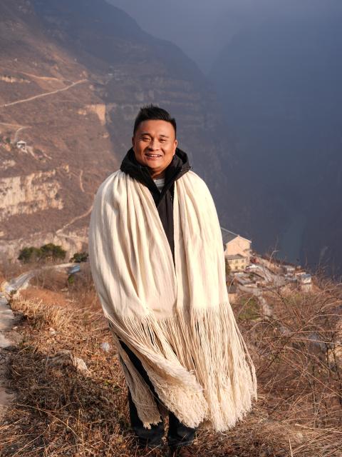 (260302) -- HANYUAN, March 2, 2026 (Xinhua) -- Zheng Wangchun poses for a photo in Gulu Village of Hanyuan County, southwest China's Sichuan Province, Jan. 28, 2026.
  Perched on a cliff at the entrance to the Dadu River Grand Canyon, Gulu Village in Sichuan Province was long isolated by poor transportation. The opening of a cableway in 2018 marked a turning point, cutting the journey from three to four hours down to just three to five minutes. 
  Zheng Wangchun is the head of the village committee and secretary of the Party committee of Gulu Village, and a deputy to the National People's Congress (NPC). Over the past years, Zheng has led villagers in developing a new path of integrated agricultural, cultural and tourism development, breathing new life into this Yi ethnic village. Villagers have opened homestays for visitors, and multiple scenic photo spots to enhance the visitor experience. At the same time, the village has expanded characteristic industries such as walnuts, Sichuan pepper, and goat farming. 
  Since taking office, Zheng has submitted suggestions including expanding internet access in rural areas and strengthening wildlife protection while minimizing its impact on farmers' livelihoods. "The smiles of villagers are the most valuable rewards for grassroots work," Zheng said. (Xinhua/Wang Xi)