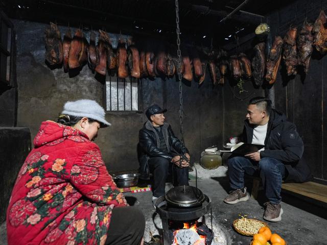 (260302) -- HANYUAN, March 2, 2026 (Xinhua) -- Zheng Wangchun (1st R) talks with villagers in Gulu Village of Hanyuan County, southwest China's Sichuan Province, Jan. 28, 2026.
  Perched on a cliff at the entrance to the Dadu River Grand Canyon, Gulu Village in Sichuan Province was long isolated by poor transportation. The opening of a cableway in 2018 marked a turning point, cutting the journey from three to four hours down to just three to five minutes. 
  Zheng Wangchun is the head of the village committee and secretary of the Party committee of Gulu Village, and a deputy to the National People's Congress (NPC). Over the past years, Zheng has led villagers in developing a new path of integrated agricultural, cultural and tourism development, breathing new life into this Yi ethnic village. Villagers have opened homestays for visitors, and multiple scenic photo spots to enhance the visitor experience. At the same time, the village has expanded characteristic industries such as walnuts, Sichuan pepper, and goat farming. 
  Since taking office, Zheng has submitted suggestions including expanding internet access in rural areas and strengthening wildlife protection while minimizing its impact on farmers' livelihoods. "The smiles of villagers are the most valuable rewards for grassroots work," Zheng said. (Xinhua/Wang Xi)