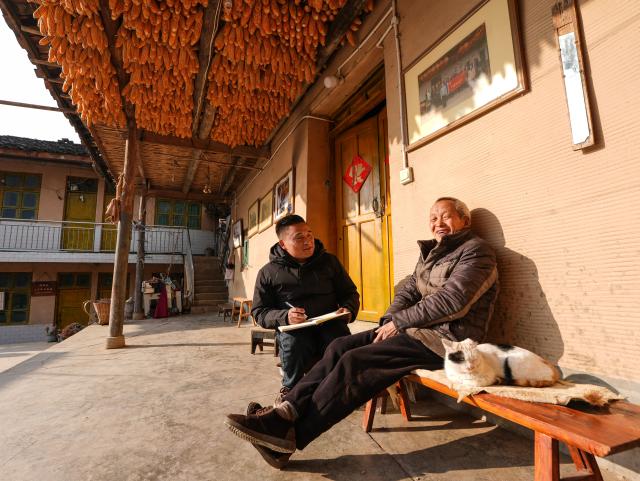(260302) -- HANYUAN, March 2, 2026 (Xinhua) -- Zheng Wangchun (L) talks with a villager in Gulu Village of Hanyuan County, southwest China's Sichuan Province, Jan. 28, 2026.
  Perched on a cliff at the entrance to the Dadu River Grand Canyon, Gulu Village in Sichuan Province was long isolated by poor transportation. The opening of a cableway in 2018 marked a turning point, cutting the journey from three to four hours down to just three to five minutes. 
  Zheng Wangchun is the head of the village committee and secretary of the Party committee of Gulu Village, and a deputy to the National People's Congress (NPC). Over the past years, Zheng has led villagers in developing a new path of integrated agricultural, cultural and tourism development, breathing new life into this Yi ethnic village. Villagers have opened homestays for visitors, and multiple scenic photo spots to enhance the visitor experience. At the same time, the village has expanded characteristic industries such as walnuts, Sichuan pepper, and goat farming. 
  Since taking office, Zheng has submitted suggestions including expanding internet access in rural areas and strengthening wildlife protection while minimizing its impact on farmers' livelihoods. "The smiles of villagers are the most valuable rewards for grassroots work," Zheng said. (Xinhua/Wang Xi)