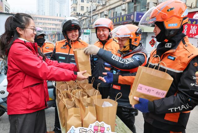 (260302) -- BEIJING, March 2, 2026 (Xinhua) -- Volunteers give deliverymen Yuanxiao, sweet glutinous rice dumplings for celebrating the Lantern Festival in Lianyungang, east China's Jiangsu Province, Feb. 28, 2026.
  Various activities were held across China to celebrate the Lantern Festival, which falls on the fifteenth day of the first month of the Chinese lunar calendar, or March 3 this year. (Photo by Wang Jianmin/Xinhua)