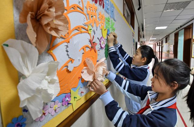 (260302) -- BEIJING, March 2, 2026 (Xinhua) -- Students decorate a display board at a primary school in Dongcheng District of Beijing, capital of China, March 2, 2026.
  A new semester kicked off for primary and secondary schools in many parts of China on Monday. (Xinhua/Li Xin)