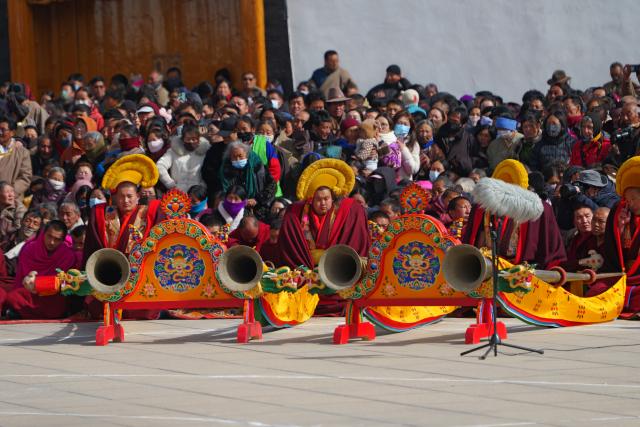 (260302) -- XIAHE, March 2, 2026 (Xinhua) -- Lamas play traditional musical instruments during an exorcism dance performance in a square at the Labrang Monastery in Xiahe County, northwest China's Gansu Province, on March 2, 2026. The annual event of exorcism dance to pray for good luck in the new year was held here on Monday. Built in 1709, Labrang Monastery is one of the six great monasteries of the Gelug Sect of Tibetan Buddhism. (Xinhua/Liu Keying)