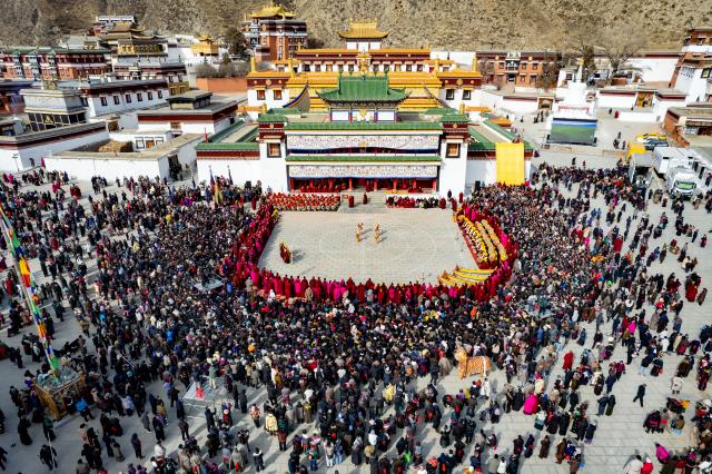 (260302) -- XIAHE, March 2, 2026 (Xinhua) -- An aerial drone photo taken on March 2, 2026 shows an event of exorcism dance at the Labrang Monastery in Xiahe County, northwest China's Gansu Province. The annual event of exorcism dance to pray for good luck in the new year was held here on Monday. Built in 1709, Labrang Monastery is one of the six great monasteries of the Gelug Sect of Tibetan Buddhism. (Xinhua/Liu Keying)