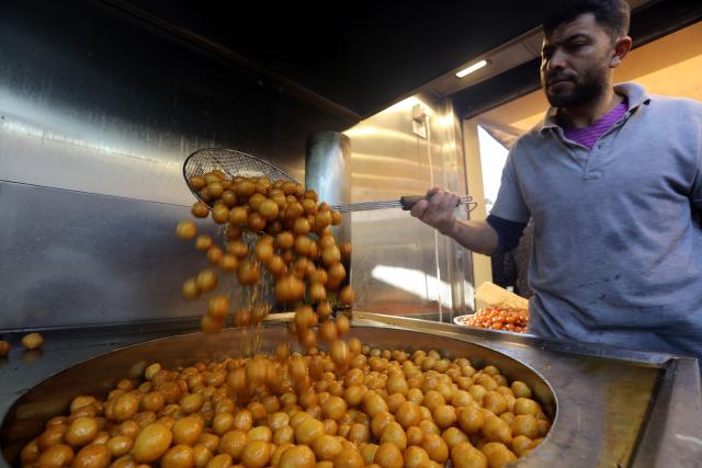 (260302) -- AMMAN, March 2, 2026 (Xinhua) -- A man prepares sweets at a market during Ramadan in Amman, Jordan, on March 2, 2026. (Photo by Mohammad Abu Ghosh/Xinhua)