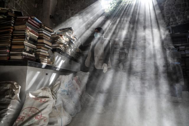 (260302) -- GAZA CITY, March 2, 2026 (Xinhua) -- A Palestinian volunteer dusts books as part of the initial rescue and restoration efforts for books and manuscripts destroyed during the Israeli bombardment of the Gaza Strip, inside the library of the Great Omari Mosque in Gaza City's Old City, on March 2, 2026. (Photo by Rizek Abdeljawad/Xinhua)