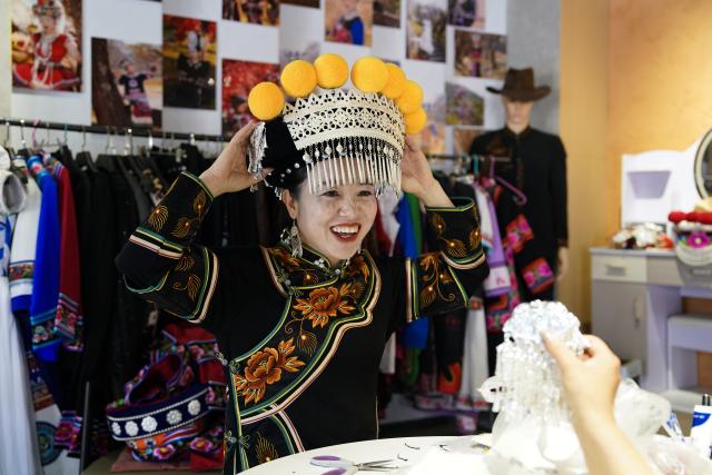 (260303) -- KUNMING, March 3, 2026 (Xinhua) -- Jin Ruirui arranges her headwear at her studio in Mouding County, southwest China's Yunnan Province, Feb. 9, 2026.
  Jin Ruirui, president of the county-level Yi embroidery association, has been dedicated to preserving the millennia-old craft while leading local embroiderers toward cultural prosperity and rural revitalization.
  With a history of more than 1,300 years, Yi embroidery features exquisite patterns and diverse stitching techniques, serving as an important carrier of ethnic Yi culture. 
  Over the years, Jin has helped more than 2,000 women find jobs. Through their efforts, the ancient craft has stepped out of the mountains and appeared on fashion week runways in cities such as Milan, New York and Paris. By blending with modern fashion design, it has repeatedly expanded into new markets and reached new audience.
  In 2023, Jin was elected a deputy to the National People's Congress (NPC). During her tenure, she has put forward proposals on issues such as the protection of Yi embroidery and related industrial development, employment, education, and healthcare.
  At this year's "two sessions," Jin will focus on the industrial growth of Yi embroidery, youth mental health and the prevention of juvenile crime. (Xinhua/Chen Xinbo)