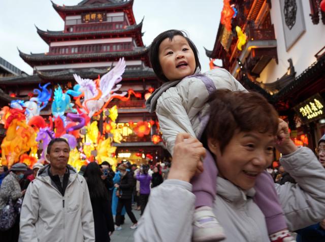 (260303) -- SHANGHAI, March 3, 2026 (Xinhua) -- A child views lanterns during the Lantern Festival celebrations at the Yuyuan Garden in Shanghai, east China, March 2, 2026. Various activities were held during this year's Lantern Festival celebrations at Yuyuan Garden of east China's Shanghai, drawing large numbers of tourists. (Xinhua/Liu Ying)