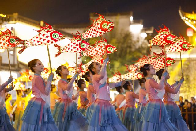 (260303) -- SHEXIAN, March 3, 2026 (Xinhua) -- Performers holding fish-shaped lanterns perform in Shexian County, Huangshan City of east China's Anhui Province, Dec. 19, 2025.
  Local villagers in Shexian have the tradition to make fish-shaped lanterns, an intangible cultural heritage, on festival days to pray for harvest and good fortune. 
   The parade with fish-shaped lanterns is an important folk cultural activity held during traditional festivals.
   Nowadays, apart from parades with fish-shaped lanterns, local people have made efforts on developing new business forms related to the fish-shaped lantern including tourism and cultural and creative products. (Photo by Shi Yalei/Xinhua)