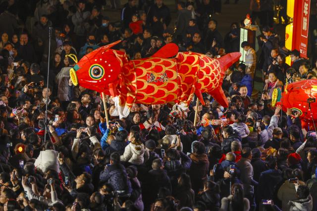 (260303) -- SHEXIAN, March 3, 2026 (Xinhua) -- People watch a fish-shaped lanterns performance in Shexian County, Huangshan City of east China's Anhui Province, Feb. 4, 2026.
  Local villagers in Shexian have the tradition to make fish-shaped lanterns, an intangible cultural heritage, on festival days to pray for harvest and good fortune. 
   The parade with fish-shaped lanterns is an important folk cultural activity held during traditional festivals.
   Nowadays, apart from parades with fish-shaped lanterns, local people have made efforts on developing new business forms related to the fish-shaped lantern including tourism and cultural and creative products. (Photo by Shi Yalei/Xinhua)