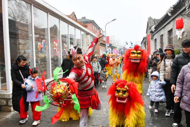 (260303) -- BEIJING, March 3, 2026 (Xinhua) -- People watch a lion dance in celebration of the Lantern Festival in Jinan, east China's Shandong Province, March 3, 2026. Across China, a variety of vibrant activities were held in celebration of the Lantern Festival, which falls on the fifteenth day of the first month of the Chinese lunar calendar, or March 3 this year. (Xinhua/Xu Suhui)