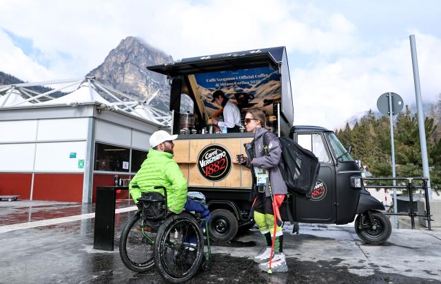 (260303) -- CORTINA D'AMPEZZO, March 3, 2026 (Xinhua) -- People chat at a coffee truck at the Paralympic Village of the Milan-Cortina 2026 Paralympic Winter Games in Cortina d'Ampezzo, Italy, March 3, 2026. (Xinhua/Wang Kaiyan)