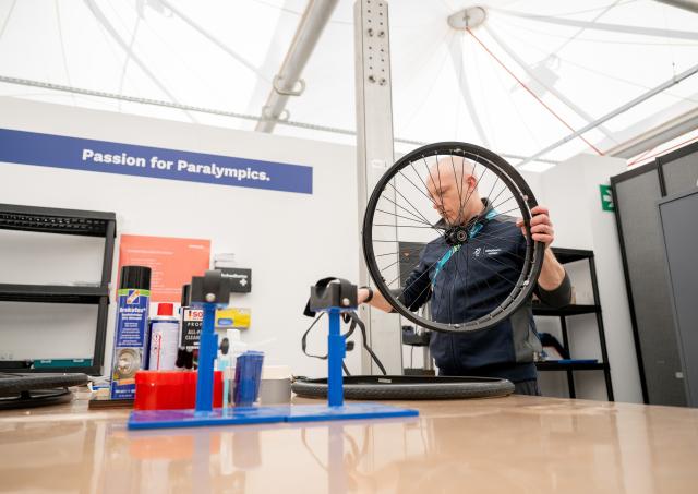 (260303) -- CORTINA D'AMPEZZO, March 3, 2026 (Xinhua) -- A staff member repairs wheelchair in the repair service center at the Paralympic Village of the Milan-Cortina 2026 Paralympic Winter Games in Cortina d'Ampezzo, Italy, March 3, 2026. (Xinhua/Lian Zhen)
