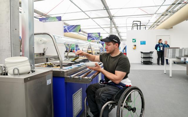 (260303) -- CORTINA D'AMPEZZO, March 3, 2026 (Xinhua) -- An athlete selects food in the dining hall at the Paralympic Village of the Milan-Cortina 2026 Paralympic Winter Games in Cortina d'Ampezzo, Italy, March 3, 2026. (Xinhua/Wang Kaiyan)