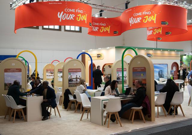 (260303) -- BERLIN, March 3, 2026 (Xinhua) -- People communicate at the exhibition area of South Africa at the ITB Berlin travel trade show in Berlin, Germany on March 3, 2026. This year's ITB Berlin travel trade show kicked off here on Tuesday and will last until March 5. First held in 1966, the event celebrates its 60th anniversary this year. (Xinhua/Zhang Haofu)