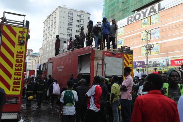 (260303) -- NAIROBI, March 3, 2026 (Xinhua) -- People gathered outside Yare Plaza where a fire broke out in Nairobi, capital of Kenya, on March 3, 2026. A fire broke out on Tuesday at Yare Plaza, a place which mainly houses clothing vendors. (Photo by Henry Naminde/Xinhua)
