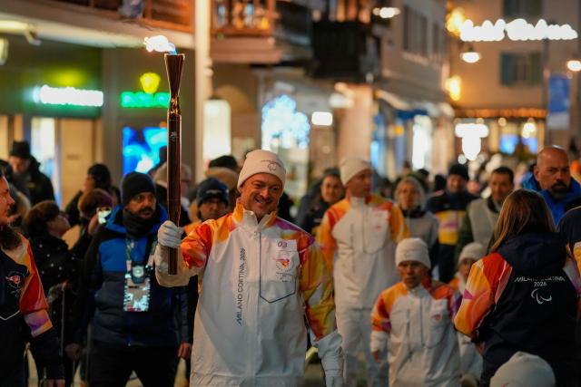 (260304) -- CORTINA D'AMPEZZO, March 4, 2026 (Xinhua) -- A torchbearer carrys the torch during the Milan-Cortina 2026 Paralympic Winter Games Torch Relay and Flame Unifying Ceremony in Cortina D'Ampezzo, Italy, March 3, 2026. (Xinhua/Lian Zhen)