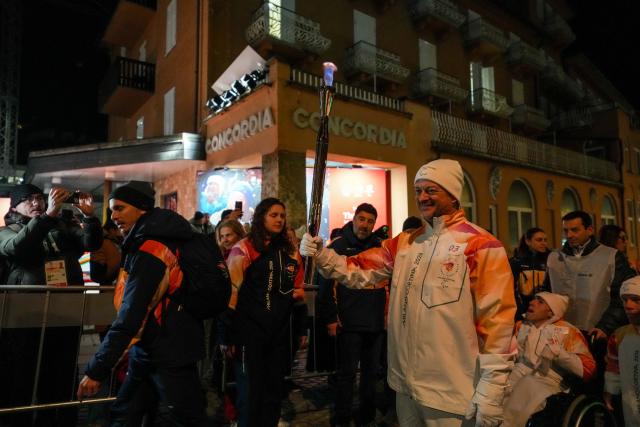 (260304) -- CORTINA D'AMPEZZO, March 4, 2026 (Xinhua) -- A torchbearer carrys the torch during the Milan-Cortina 2026 Paralympic Winter Games Torch Relay and Flame Unifying Ceremony in Cortina D'Ampezzo, Italy, March 3, 2026. (Xinhua/Lian Zhen)