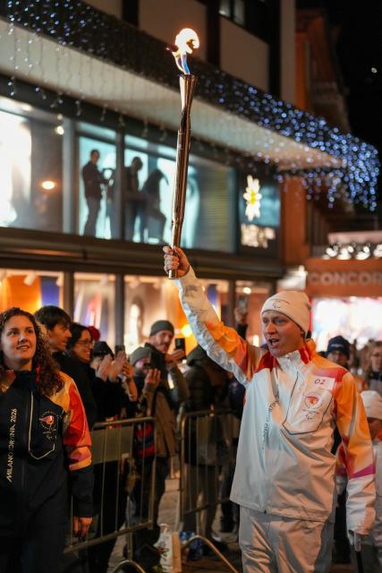 (260304) -- CORTINA D'AMPEZZO, March 4, 2026 (Xinhua) -- A torchbearer carrys the torch during the Milan-Cortina 2026 Paralympic Winter Games Torch Relay and Flame Unifying Ceremony in Cortina D'Ampezzo, Italy, March 3, 2026. (Xinhua/Lian Zhen)