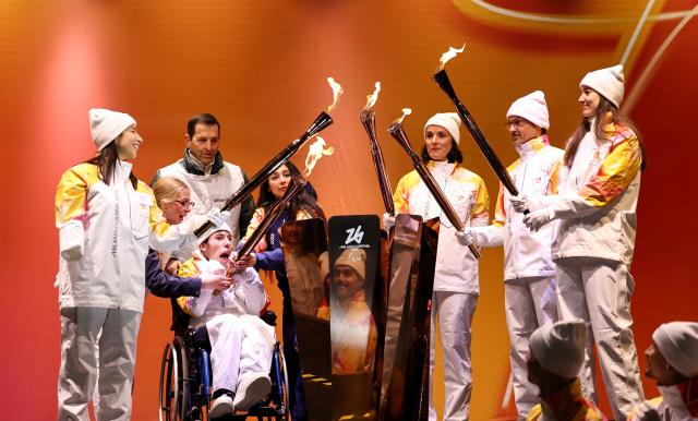 (260304) -- CORTINA D'AMPEZZO, March 4, 2026 (Xinhua) -- Torchbearers unify the flame during the Milan-Cortina 2026 Paralympic Winter Games Torch Relay and Flame Unifying Ceremony in Cortina D'Ampezzo, Italy, March 3, 2026. (Xinhua/Wang Kaiyan)
