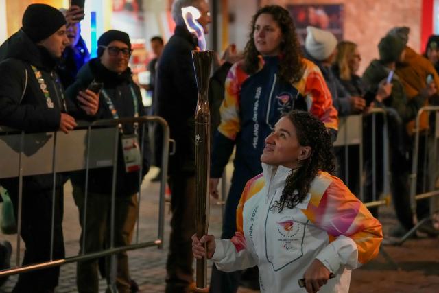 (260304) -- CORTINA D'AMPEZZO, March 4, 2026 (Xinhua) -- A torchbearer carrys the torch during the Milan-Cortina 2026 Paralympic Winter Games Torch Relay and Flame Unifying Ceremony in Cortina D'Ampezzo, Italy, March 3, 2026. (Xinhua/Lian Zhen)