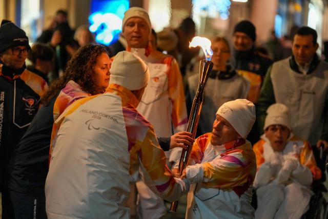 (260304) -- CORTINA D'AMPEZZO, March 4, 2026 (Xinhua) -- A torchbearer carrys the torch during the Milan-Cortina 2026 Paralympic Winter Games Torch Relay and Flame Unifying Ceremony in Cortina D'Ampezzo, Italy, March 3, 2026. (Xinhua/Lian Zhen)