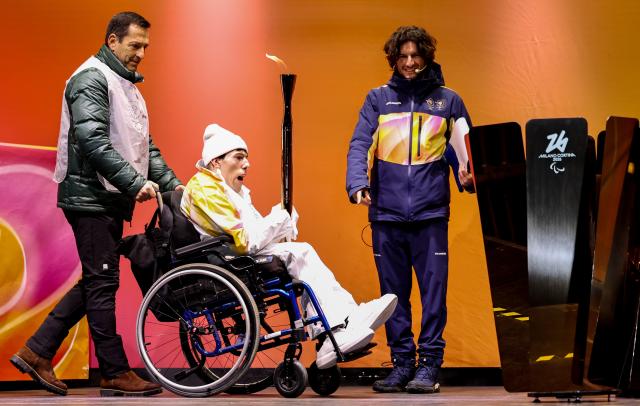 (260304) -- CORTINA D'AMPEZZO, March 4, 2026 (Xinhua) -- A torchbearer is seen during the Milan-Cortina 2026 Paralympic Winter Games Torch Relay and Flame Unifying Ceremony in Cortina D'Ampezzo, Italy, March 3, 2026. (Xinhua/Wang Kaiyan)