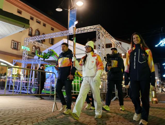 (260304) -- CORTINA D'AMPEZZO, March 4, 2026 (Xinhua) -- A torchbearer carrys the torch during the Milan-Cortina 2026 Paralympic Winter Games Torch Relay and Flame Unifying Ceremony in Cortina D'Ampezzo, Italy, March 3, 2026. (Xinhua/Mou Yu)