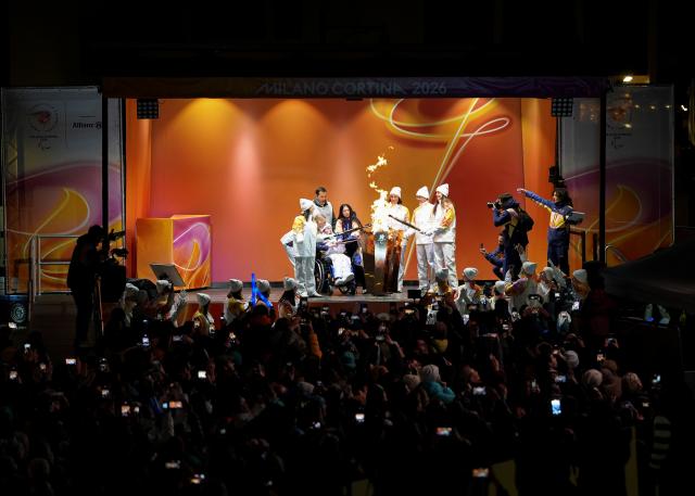 (260304) -- CORTINA D'AMPEZZO, March 4, 2026 (Xinhua) -- Torchbearers unify the flame during the Milan-Cortina 2026 Paralympic Winter Games Torch Relay and Flame Unifying Ceremony in Cortina D'Ampezzo, Italy, March 3, 2026. (Xinhua/Hou Zhaokang)