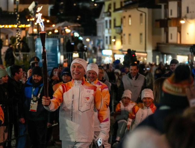 (260304) -- CORTINA D'AMPEZZO, March 4, 2026 (Xinhua) -- A torchbearer carrys the torch during the Milan-Cortina 2026 Paralympic Winter Games Torch Relay and Flame Unifying Ceremony in Cortina D'Ampezzo, Italy, March 3, 2026. (Xinhua/Lian Zhen)