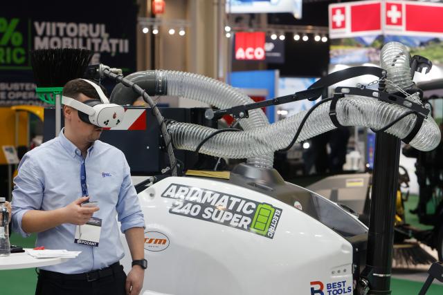 (260304) -- BUCHAREST, March 4, 2026 (Xinhua) -- An exhibitor demonstrates a virtual reality device next to a street vacuum cleaner during the first day of the Green Energy Expo & Romenvirotec event at Romexpo in Bucharest, Romania, March 3, 2026.
  The event is a regional platform for technologies in green energy, water, waste and sustainable cities. (Photo by Cristian Cristel/Xinhua)