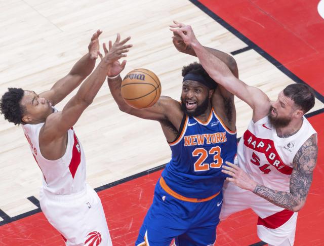 (260304) -- TORONTO, March 4, 2026 (Xinhua) -- Scottie Barnes (L) and Sandro Mamukelashvili (R) of Toronto Raptors fight for a rebound with Mitchell Robinson of New York Knicks during the 2025-2026 NBA regular season game between Toronto Raptors and New York Knicks in Toronto, Canada, on March 3, 2026. (Photo by Zou Zheng/Xinhua)