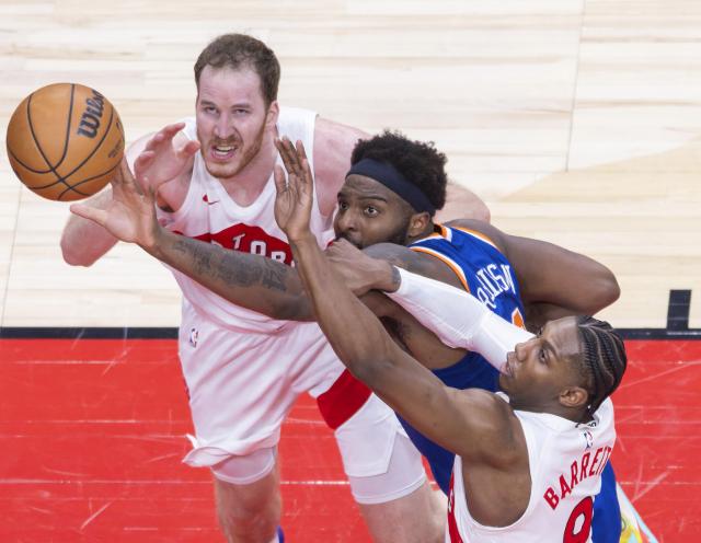 (260304) -- TORONTO, March 4, 2026 (Xinhua) -- RJ Barrett (R) and Jakob Poeltl (L) of Toronto Raptors fight for a rebound with Mitchell Robinson of New York Knicks during the 2025-2026 NBA regular season game between Toronto Raptors and New York Knicks in Toronto, Canada, on March 3, 2026. (Photo by Zou Zheng/Xinhua)