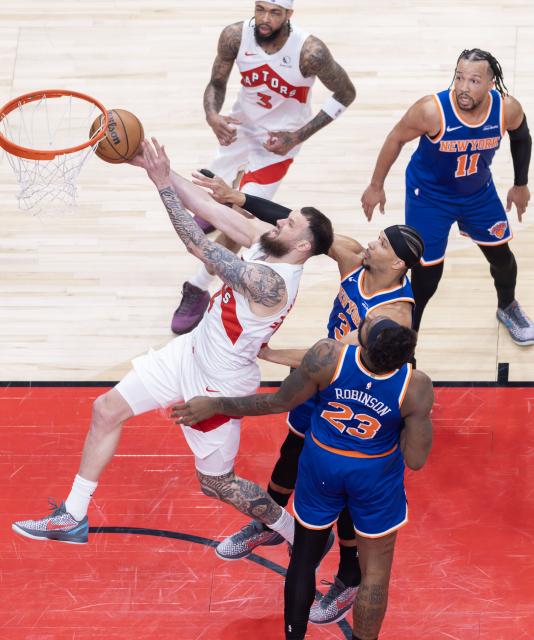 (260304) -- TORONTO, March 4, 2026 (Xinhua) -- Sandro Mamukelashvili (L, front) of Toronto Raptors goes for a layup during the 2025-2026 NBA regular season game between Toronto Raptors and New York Knicks in Toronto, Canada, on March 3, 2026. (Photo by Zou Zheng/Xinhua)