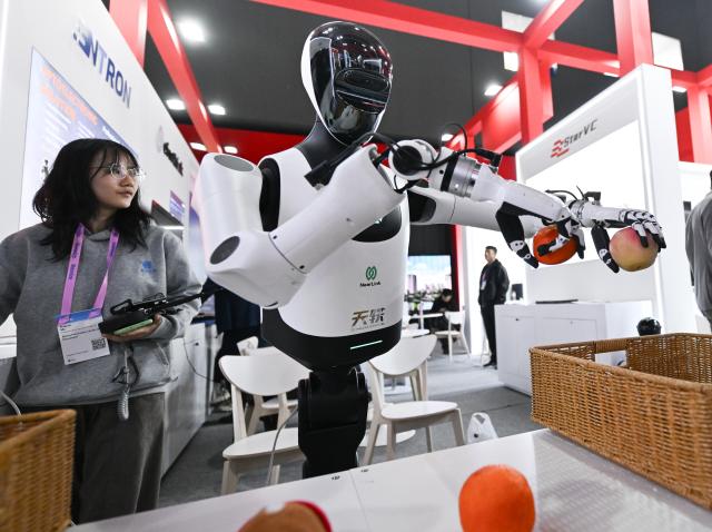 (260304) -- BARCELONA, March 4, 2026 (Xinhua) -- A humanoid robot made by Humanoid sorts things during the 2026 Mobile World Congress (MWC) in Barcelona, Spain, March 3, 2026.
  The 2026 Mobile World Congress (MWC) opened on Monday in Barcelona, Spain. According to its organizers, a China Pavilion has been set up at the congress for the first time, featuring major Chinese companies including China Mobile, China Unicom, Huawei, ZTE, Honor and Xiaomi, showcasing their latest advancements in mobile communications and AI technologies. (Xinhua/Cheng Min)