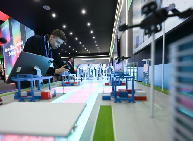 (260304) -- BARCELONA, March 4, 2026 (Xinhua) -- A staff member demonstrates a smart port model created by China Mobile during the 2026 Mobile World Congress (MWC) in Barcelona, Spain, March 3, 2026.
  The 2026 Mobile World Congress (MWC) opened on Monday in Barcelona, Spain. According to its organizers, a China Pavilion has been set up at the congress for the first time, featuring major Chinese companies including China Mobile, China Unicom, Huawei, ZTE, Honor and Xiaomi, showcasing their latest advancements in mobile communications and AI technologies. (Xinhua/Cheng Min)