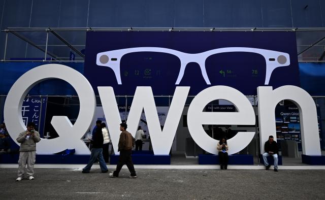 (260304) -- BARCELONA, March 4, 2026 (Xinhua) -- People walk past the booth of Qwen during the 2026 Mobile World Congress (MWC) in Barcelona, Spain, March 2, 2026.
  The 2026 Mobile World Congress (MWC) opened on Monday in Barcelona, Spain. According to its organizers, a China Pavilion has been set up at the congress for the first time, featuring major Chinese companies including China Mobile, China Unicom, Huawei, ZTE, Honor and Xiaomi, showcasing their latest advancements in mobile communications and AI technologies. (Xinhua/Cheng Min)