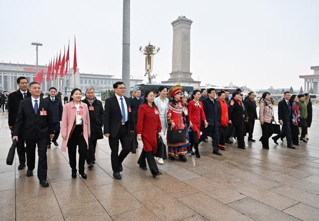 (260305) -- BEIJING, March 5, 2026 (Xinhua) -- Deputies to the 14th National People's Congress (NPC) walk towards the Great Hall of the People for the opening meeting of the fourth session of the 14th NPC in Beijing, capital of China, March 5, 2026. (Xinhua/Chen Yichen)
