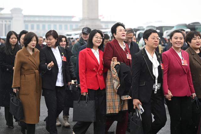 (260305) -- BEIJING, March 5, 2026 (Xinhua) -- Deputies to the 14th National People's Congress (NPC) walk towards the Great Hall of the People for the opening meeting of the fourth session of the 14th NPC in Beijing, capital of China, March 5, 2026. (Xinhua/Jin Liangkuai)