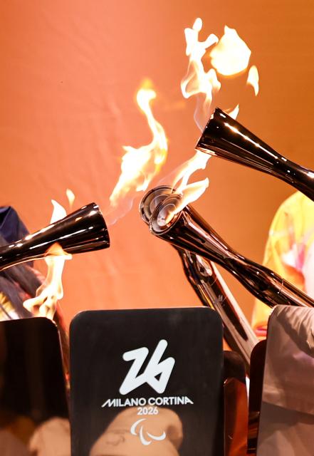 (260305) -- BEIJING, March 5, 2026 (Xinhua) -- Torchbearers unify the flame during the Milan-Cortina 2026 Paralympic Winter Games Torch Relay and Flame Unifying Ceremony in Cortina D'Ampezzo, Italy, March 3, 2026. (Xinhua/Wang Kaiyan)