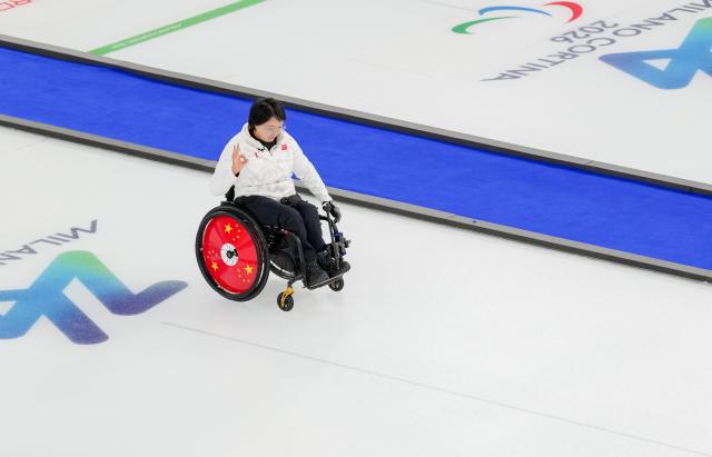 (260305) -- CORTINA D'AMPEZZO, March 5, 2026 (Xinhua) -- Wang Meng of China competes during the wheelchair curling mixed doubles round robin session 1 match between China and Japan at the Milan-Cortina 2026 Paralympic Winter Games in Cortina D'ampezzo, Italy, March 4, 2026. (Xinhua/Lian Zhen)