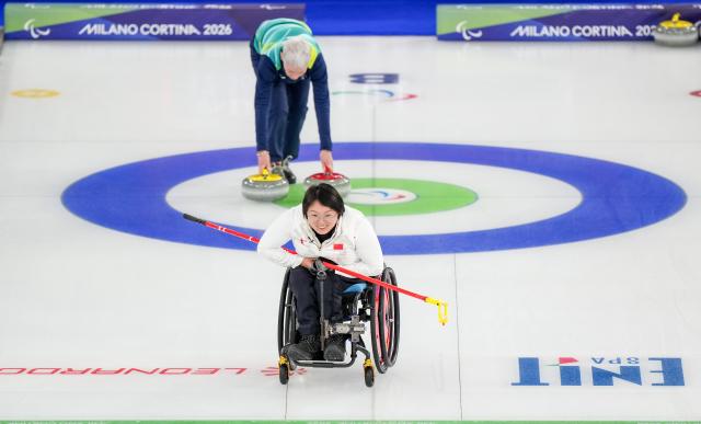 (260305) -- CORTINA D'AMPEZZO, March 5, 2026 (Xinhua) -- Wang Meng of China competes during the wheelchair curling mixed doubles round robin session 1 match between China and Japan at the Milan-Cortina 2026 Paralympic Winter Games in Cortina D'ampezzo, Italy, March 4, 2026. (Xinhua/Lian Zhen)