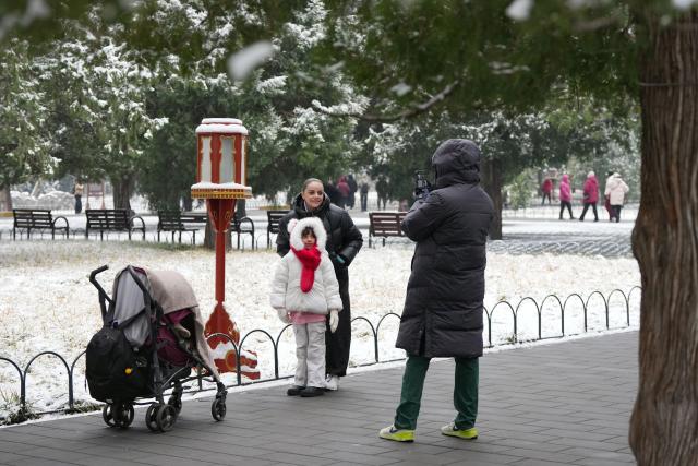 (260305) -- BEIJING, March 5, 2026 (Xinhua) -- Foreign tourists pose for photos at the Tiantan (Temple of Heaven) Park in Beijing, capital of China, March 5, 2026. Beijing has witnessed a spring snowfall from Wednesday to Thursday. (Xinhua/Ju Huanzong)