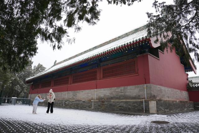 (260305) -- BEIJING, March 5, 2026 (Xinhua) -- Tourists visit the Tiantan (Temple of Heaven) Park in Beijing, capital of China, March 5, 2026. Beijing has witnessed a spring snowfall from Wednesday to Thursday. (Xinhua/Ju Huanzong)
