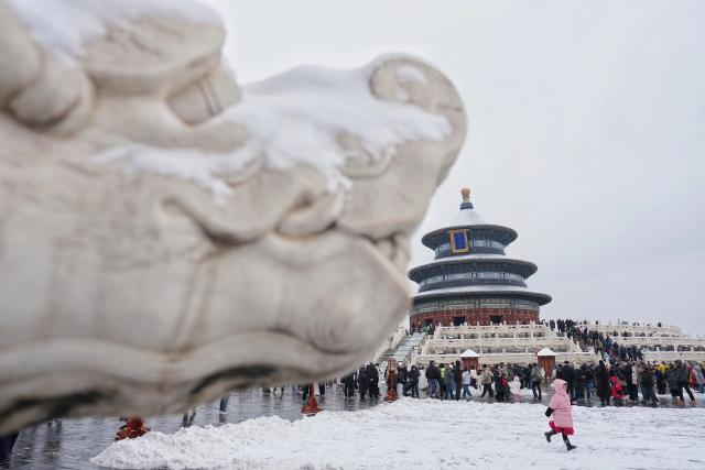 (260305) -- BEIJING, March 5, 2026 (Xinhua) -- Tourists visit the Tiantan (Temple of Heaven) Park in Beijing, capital of China, March 5, 2026. Beijing has witnessed a spring snowfall from Wednesday to Thursday. (Xinhua/Ju Huanzong)