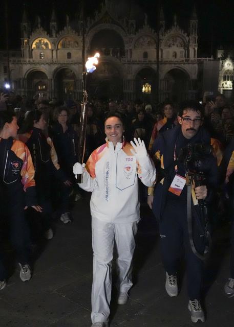 (260305) -- VENICE, March 5, 2026 (Xinhua) -- Torchbearer Matilde Villa carries the torch during the Milan-Cortina 2026 Paralympic Winter Games Torch Relay in Venice, Italy, March 4, 2026. (Xinhua/Hou Jun)