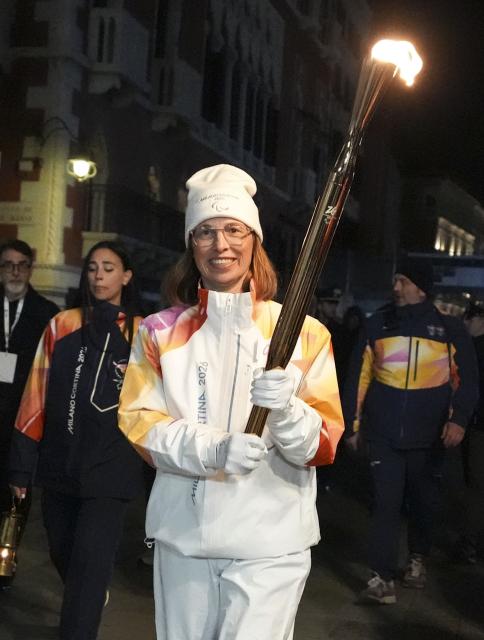 (260305) -- VENICE, March 5, 2026 (Xinhua) -- Torchbearer Eike Doerte Burgel carries the torch during the Milan-Cortina 2026 Paralympic Winter Games Torch Relay in Venice, Italy, March 4, 2026. (Xinhua/Hou Jun)