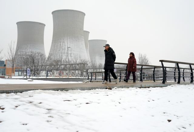 (260305) -- BEIJING, March 5, 2026 (Xinhua) -- Tourists visit the Shougang Park after a snowfall in Beijing, capital of China, March 5, 2026. Beijing has witnessed a spring snowfall from Wednesday to Thursday. (Xinhua/Zhang Chenlin)