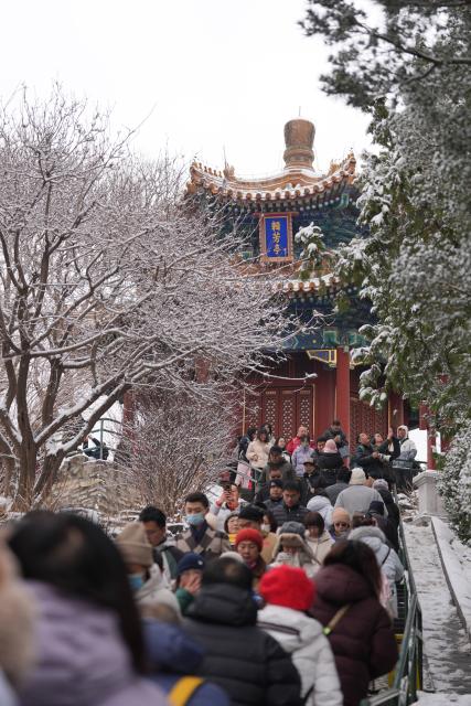 (260305) -- BEIJING, March 5, 2026 (Xinhua) -- Tourists visit the Jingshan Park after a snowfall in Beijing, capital of China, March 5, 2026. Beijing has witnessed a spring snowfall from Wednesday to Thursday. (Xinhua/Xie Han)